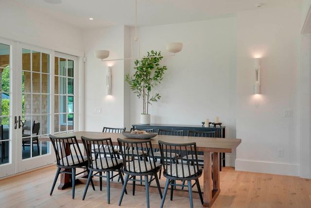 a dining room with furniture potted plants and wooden floor