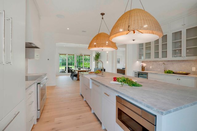 a large kitchen with stainless steel appliances a large counter space a large window and cabinets