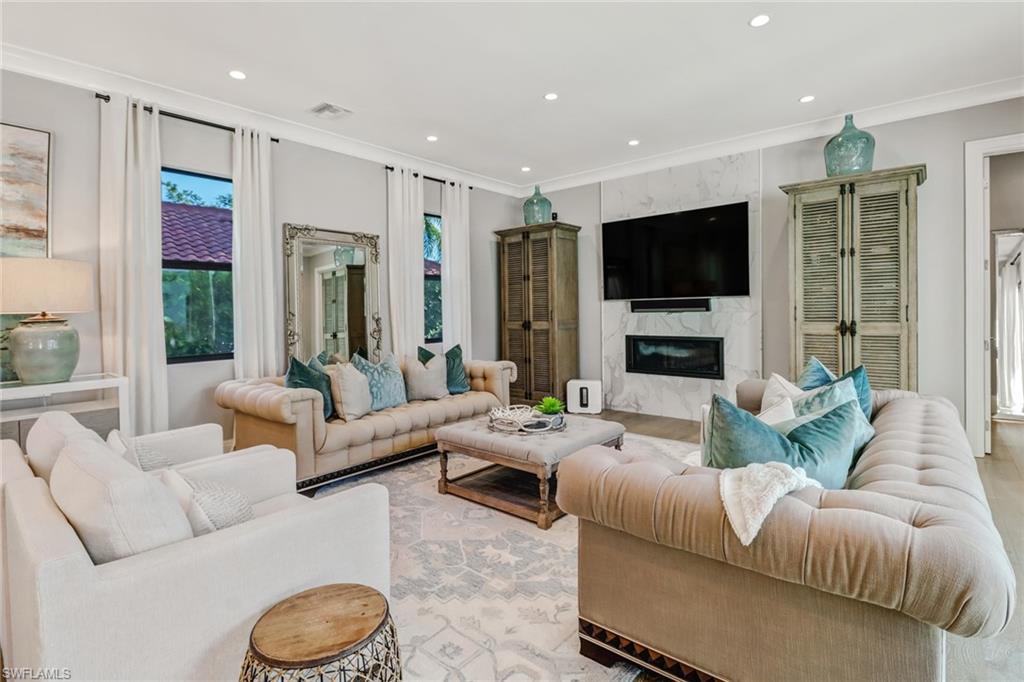 1919 Manchester Circle Naples, FL 34109 - Photo 43 of 45 a living room with furniture flat screen tv and a large window