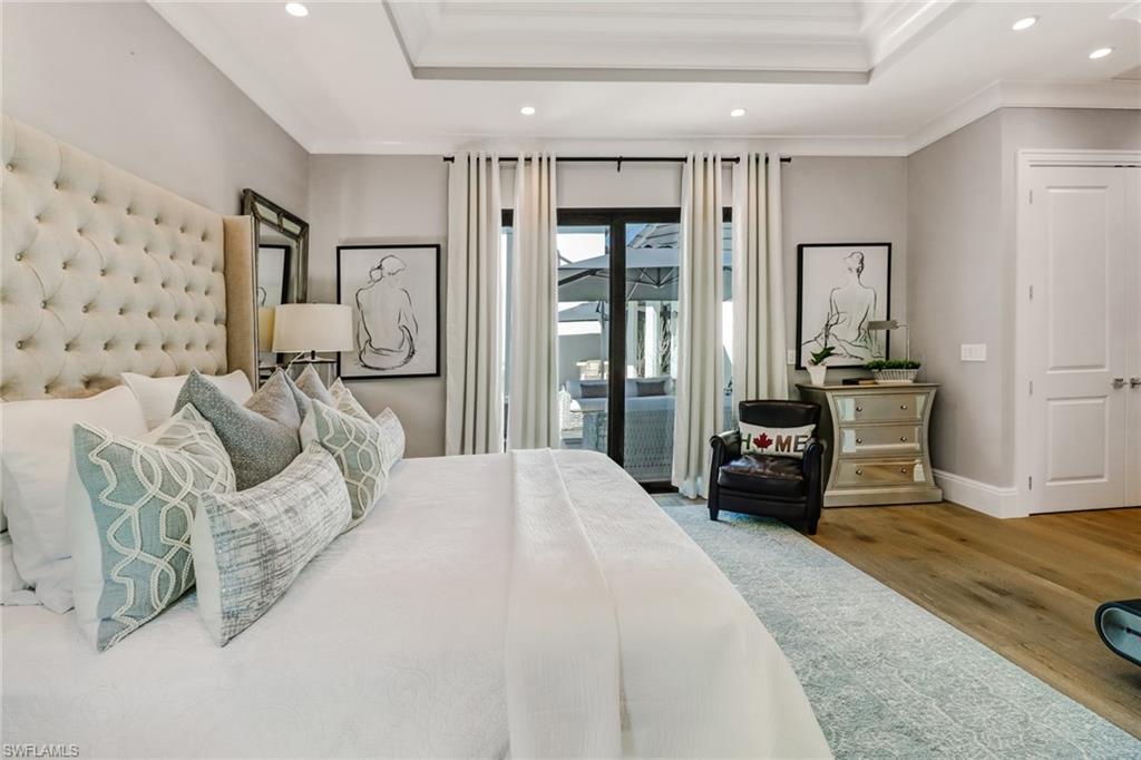 1919 Manchester Circle Naples, FL 34109 - Photo 13 of 45 a bedroom with furniture and large windows