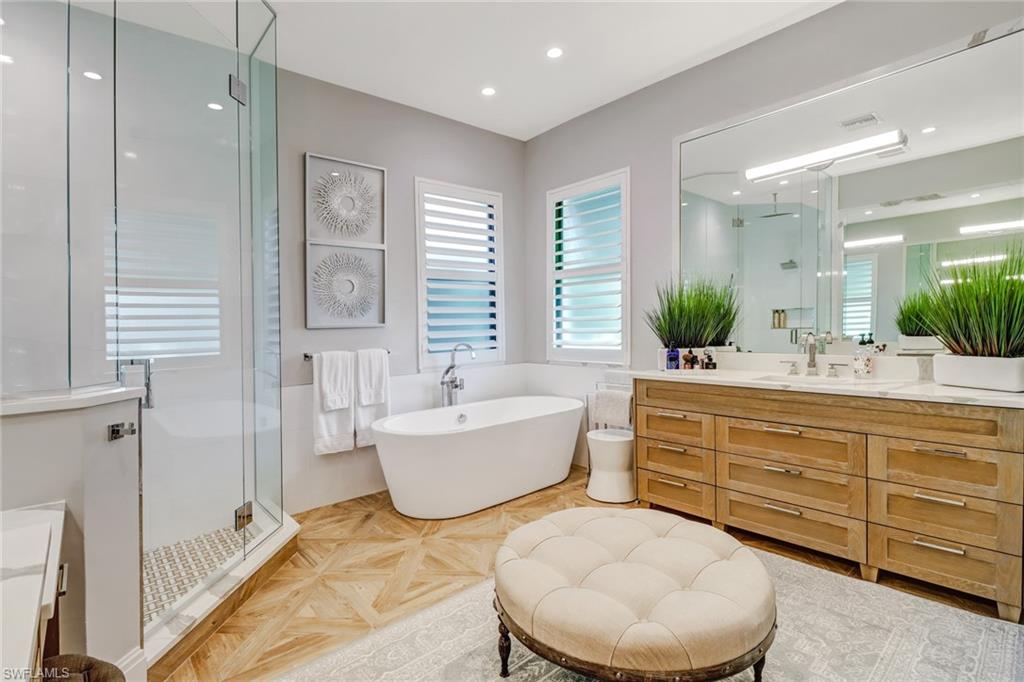 1919 Manchester Circle Naples, FL 34109 - Photo 14 of 45 a bathroom with a tub sink and mirror