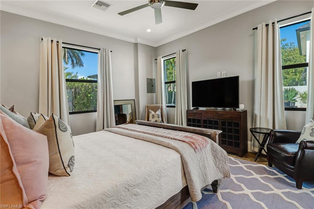 1919 Manchester Circle Naples, FL 34109 - Photo 16 of 45 a bedroom with a bed and a flat screen tv