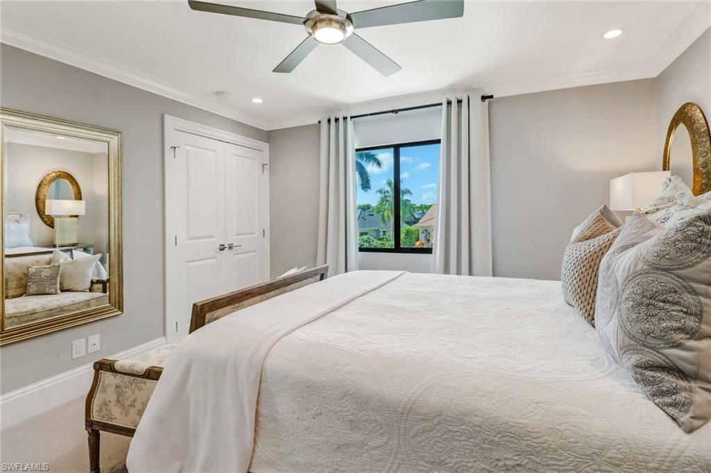 1919 Manchester Circle Naples, FL 34109 - Photo 24 of 45 a bedroom with a bed and a chandelier