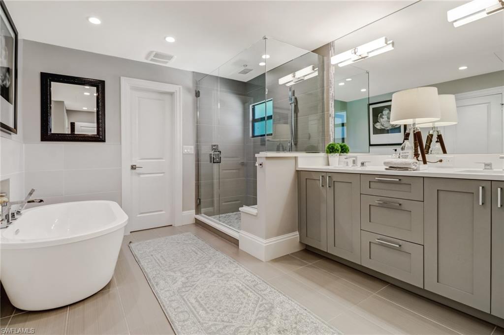 1919 Manchester Circle Naples, FL 34109 - Photo 27 of 45 a bathroom with a double vanity sink mirror and bathtub