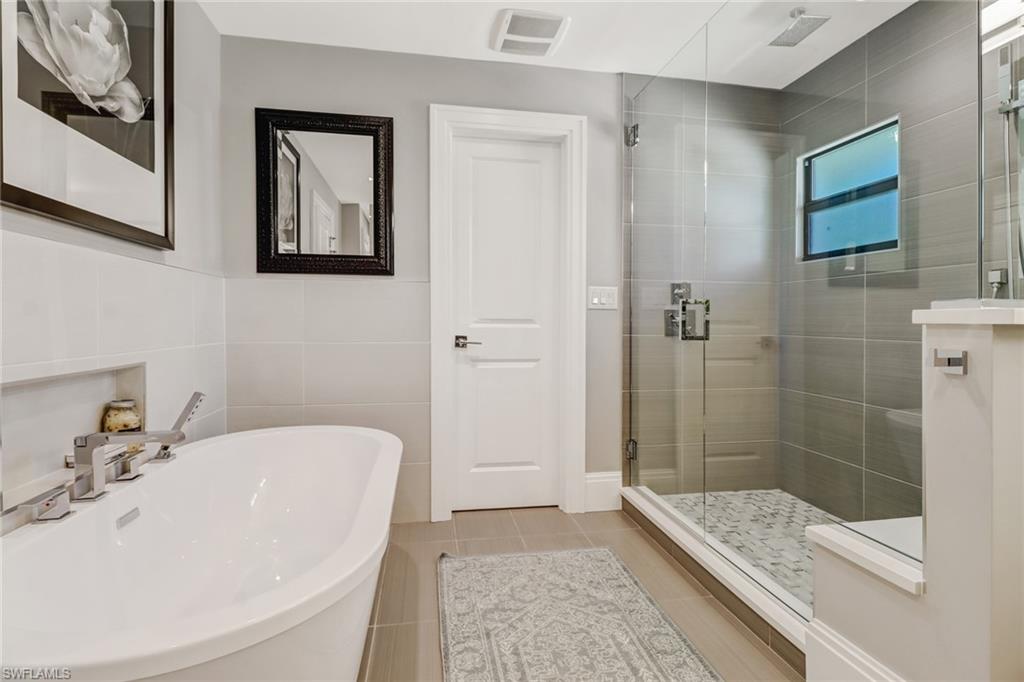 1919 Manchester Circle Naples, FL 34109 - Photo 28 of 45 a bathroom with a bathtub and shower