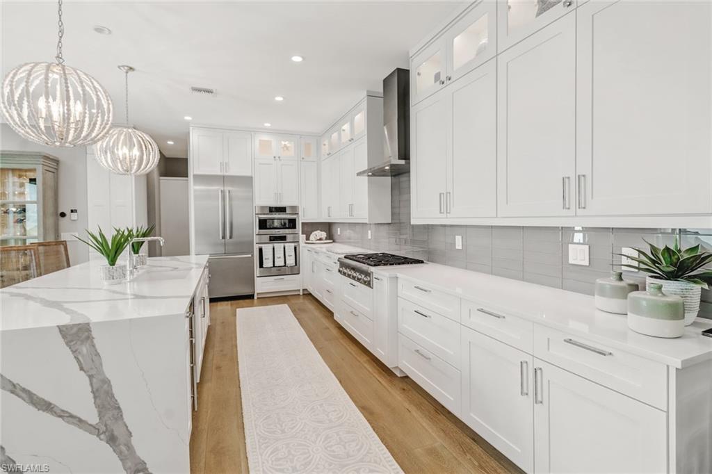 1919 Manchester Circle Naples, FL 34109 - Photo 30 of 45 a large kitchen with stainless steel appliances kitchen island granite countertop a sink a stove and cabinets