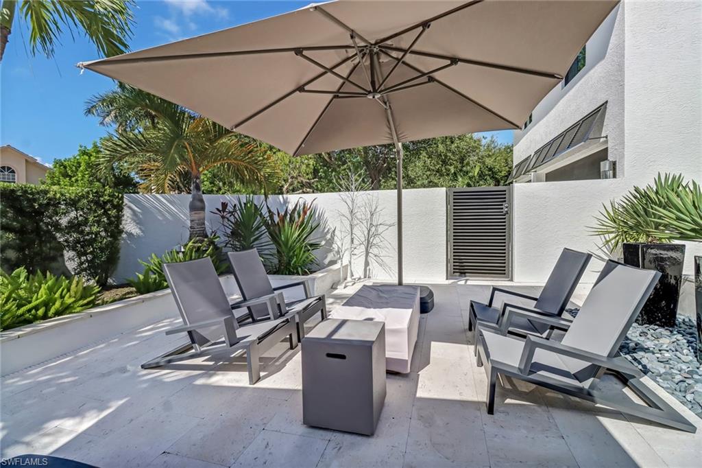 1919 Manchester Circle Naples, FL 34109 - Photo 32 of 45 a view of patio with furniture and table under an umbrella