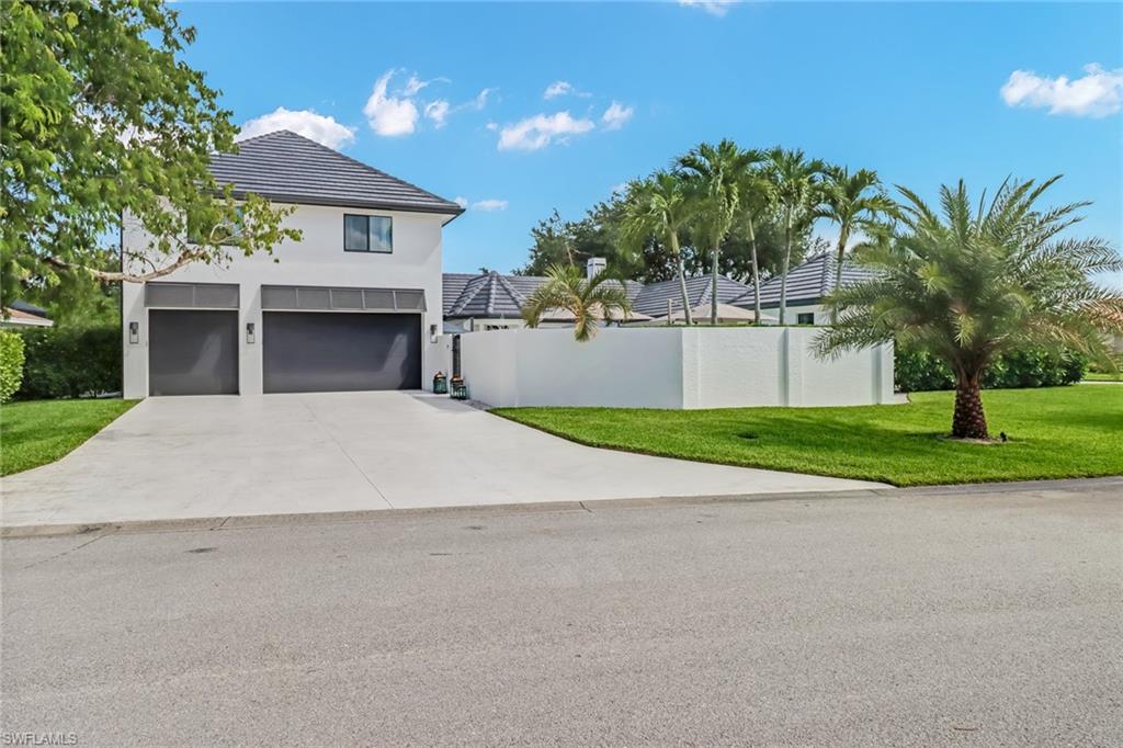 1919 Manchester Circle Naples, FL 34109 - Photo 35 of 45 a view of a house with a yard and potted plants