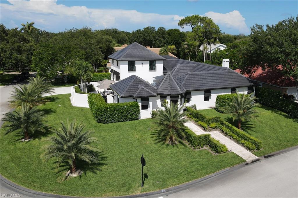 1919 Manchester Circle Naples, FL 34109 - Photo 42 of 45 a aerial view of a house with a yard table and chairs