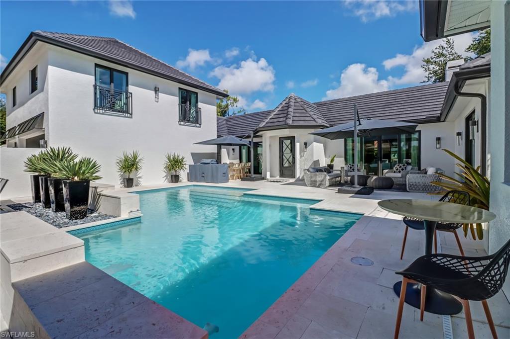 1919 Manchester Circle Naples, FL 34109 - Photo 8 of 45 a backyard of a house with table and chairs