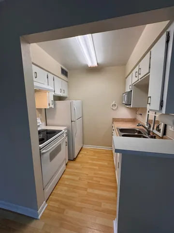 a kitchen with a sink stove and refrigerator