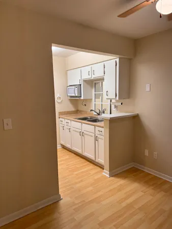 a kitchen with a sink cabinets and wooden floor
