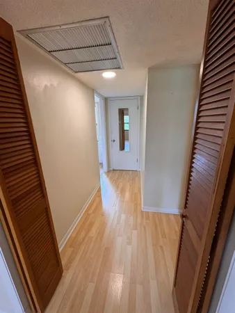 a view of a hallway with wooden floor and staircase