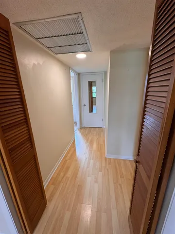 a view of a hallway with wooden floor and staircase