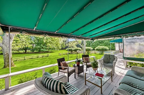 a view of a chairs and table in patio with a yard