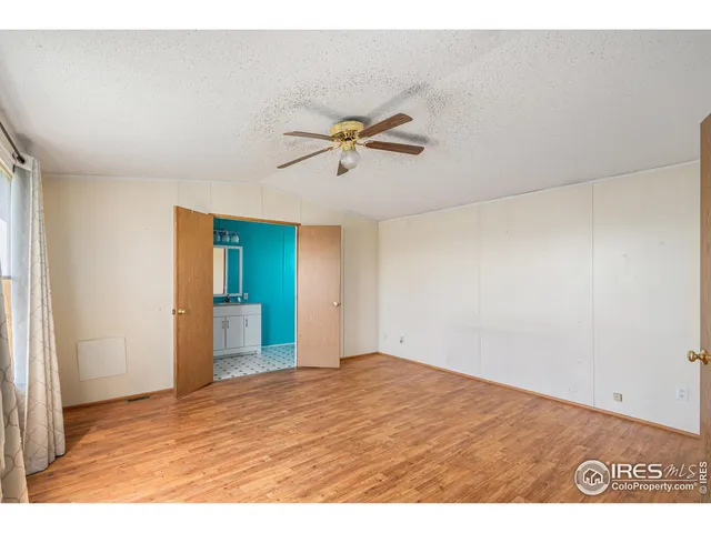 an empty room with closet and a chandelier fan