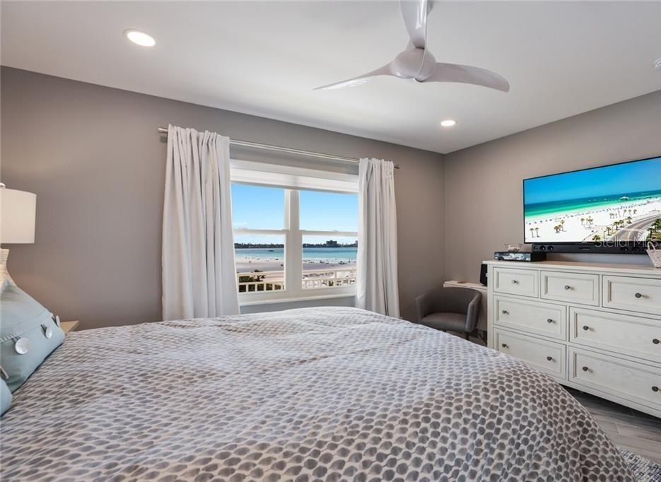 2110 Benjamin Franklin Drive, Unit 503SEA Sarasota, FL 34236 - Photo 14 of 29 a bedroom with a large bed and a flat tv screen on dresser