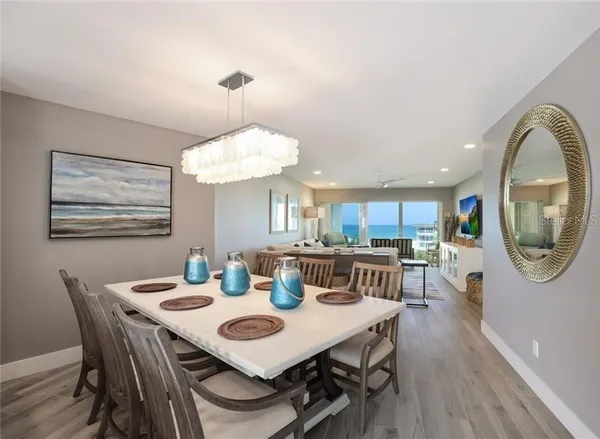 a view of a dining room with furniture a chandelier and wooden floor