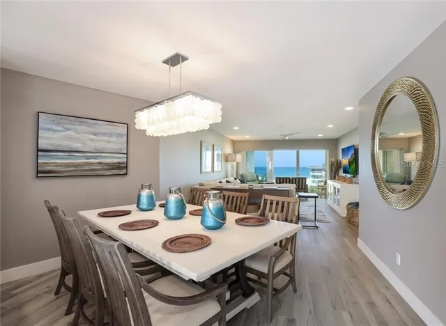 a view of a dining room with furniture a chandelier and wooden floor