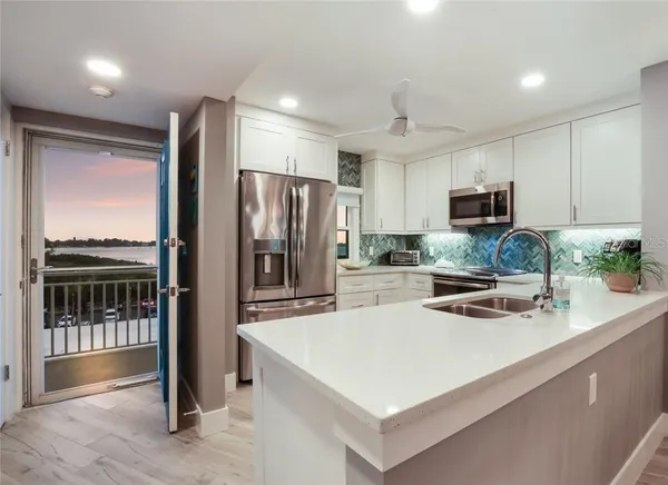 a kitchen with kitchen island a counter top space appliances and a sink