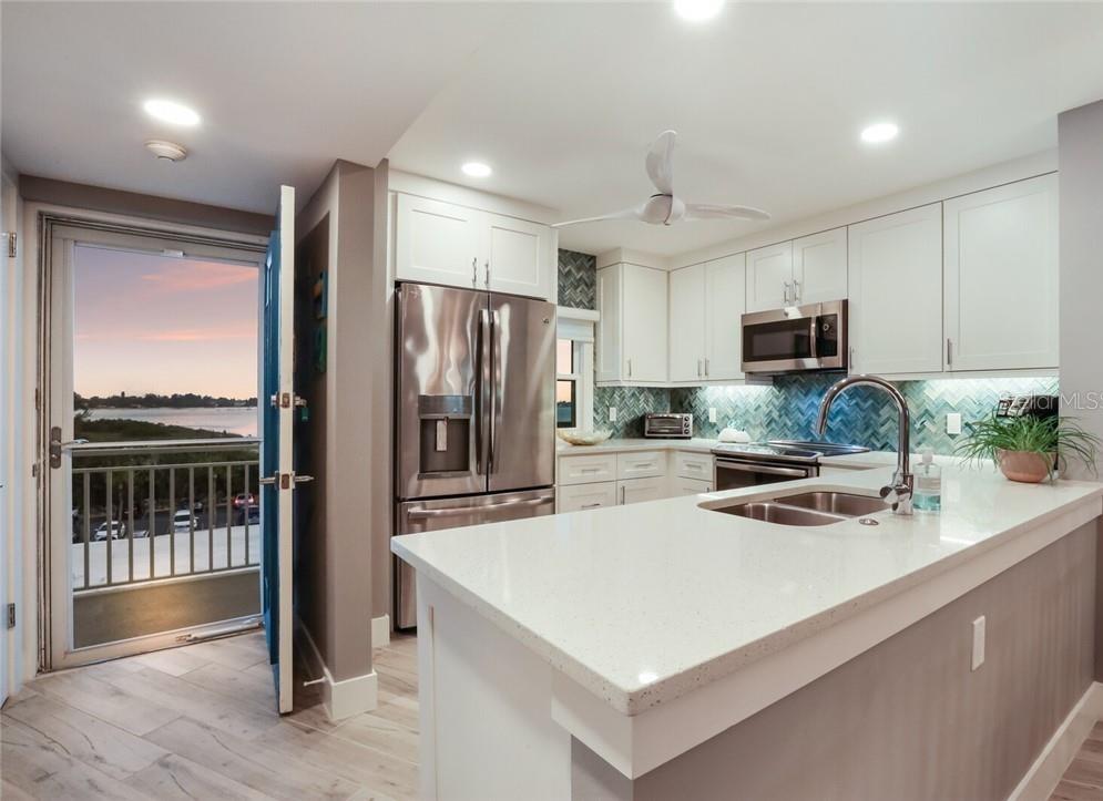 2110 Benjamin Franklin Drive, Unit 503SEA Sarasota, FL 34236 - Photo 7 of 29 a kitchen with kitchen island a counter top space appliances and a sink