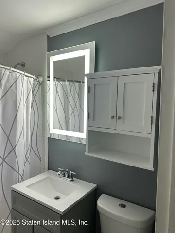 a bathroom with a sink a toilet and a mirror