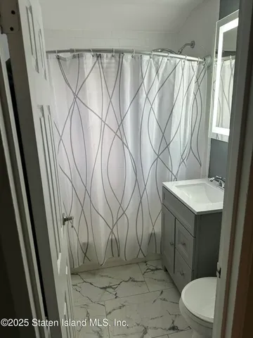 a bathroom with a sink a toilet and shower curtain