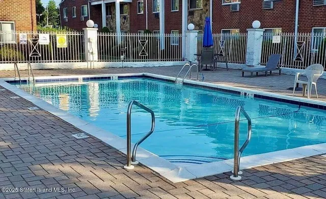 a swimming pool with outdoor seating and yard