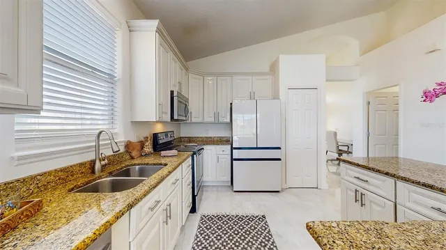 a kitchen with stainless steel appliances granite countertop a sink stove and refrigerator
