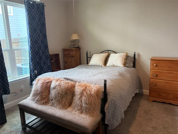 a bed sitting in a bedroom next to a window with lamp