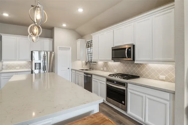 a large kitchen with a table and chairs