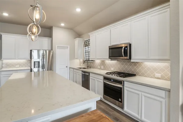 a kitchen with stainless steel appliances a stove microwave and cabinets