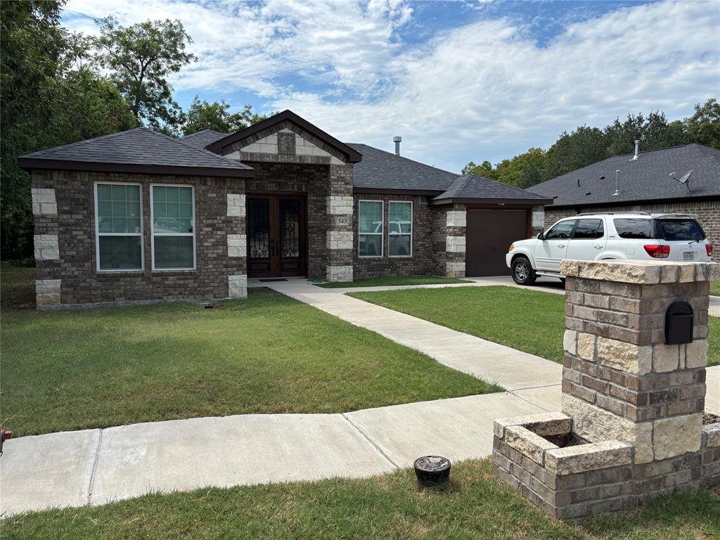 343 North Morris Street Gainesville, TX 76240 - Photo 2 of 18 a front view of a house with a garden and yard
