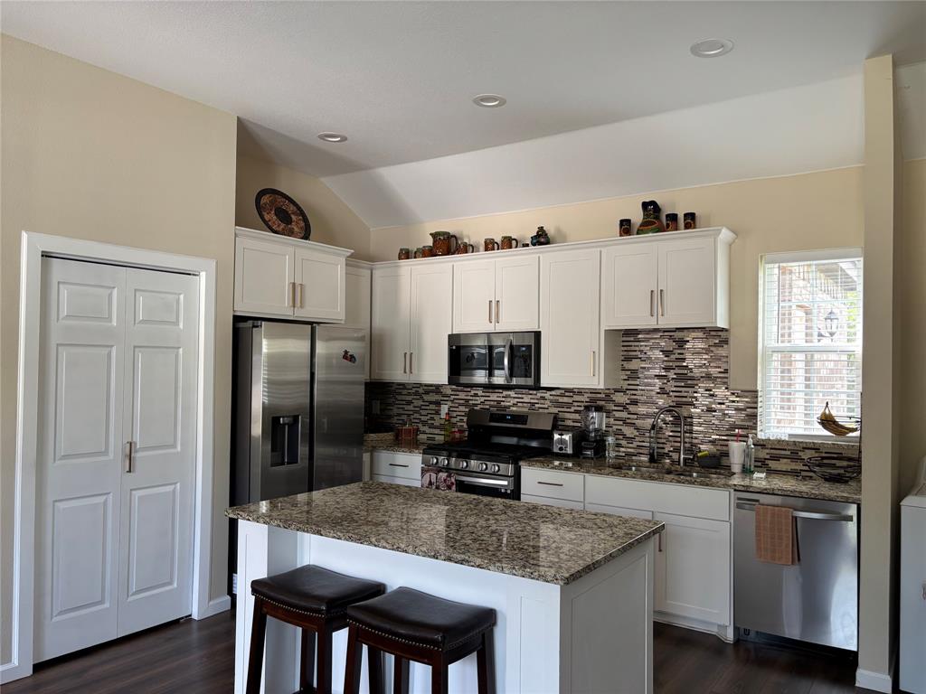 343 North Morris Street Gainesville, TX 76240 - Photo 3 of 18 a kitchen with stainless steel appliances granite countertop a sink stove and refrigerator