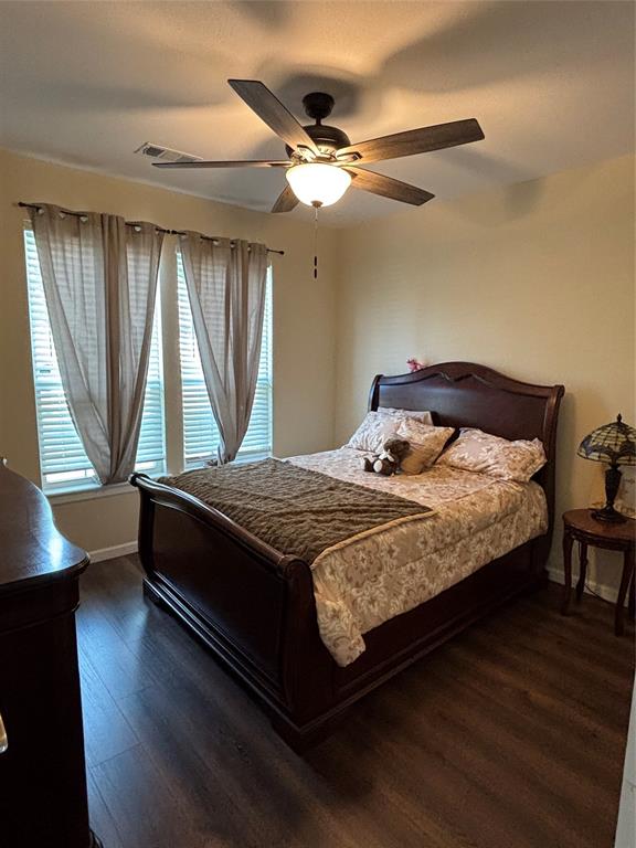 343 North Morris Street Gainesville, TX 76240 - Photo 6 of 18 a bedroom with a bed and a chandelier