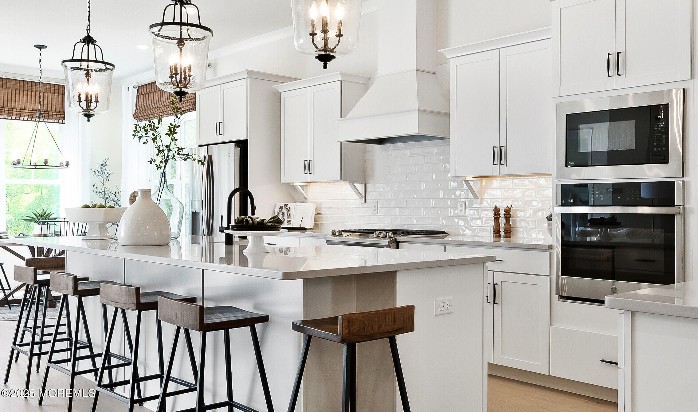 176 Highway 33, Unit IBIZA II LOFT Manalapan, NJ 07726 - Photo 5 of 39 a kitchen with stainless steel appliances kitchen island granite countertop a table chairs in it and white cabinets