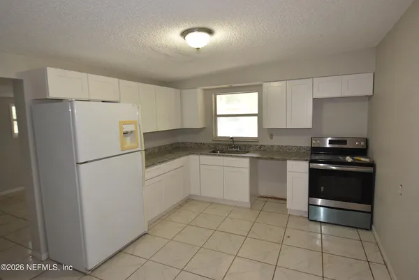 a kitchen with white cabinets and a sink