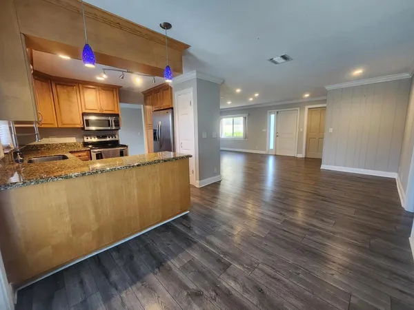 a kitchen with stainless steel appliances granite countertop a stove a sink and a refrigerator