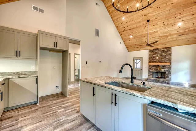 a kitchen with stainless steel appliances granite countertop a sink a stove and a refrigerator