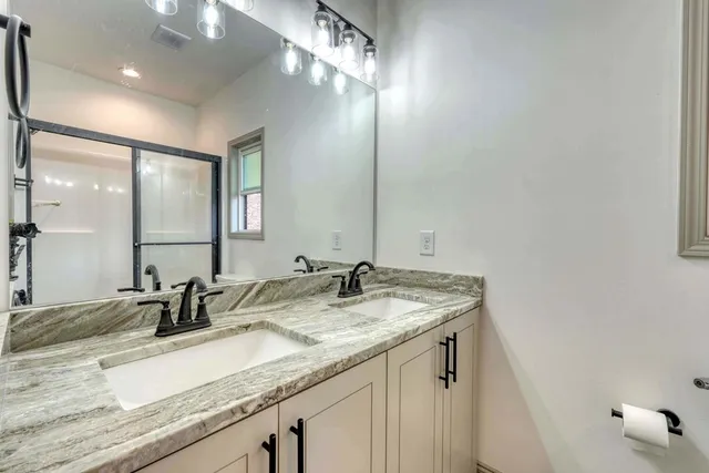 a bathroom with a granite countertop sink and a mirror