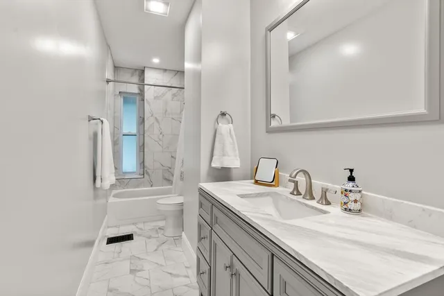 a bathroom with a sink a toilet and shower