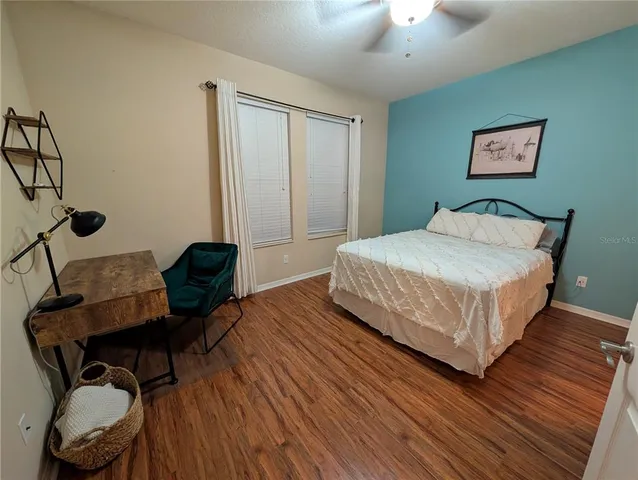 a bedroom with a bed and wooden floor