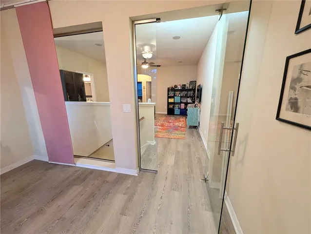 a view of a hallway view with living room and wooden floor