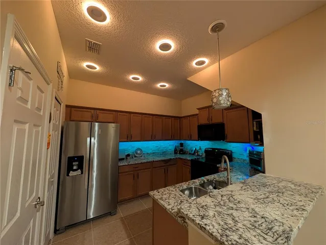a kitchen with stainless steel appliances granite countertop a refrigerator and a sink