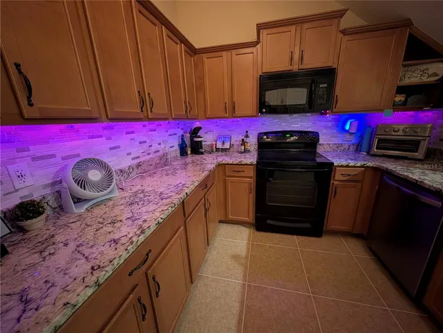 a kitchen with stainless steel appliances granite countertop a stove top oven microwave and cabinets