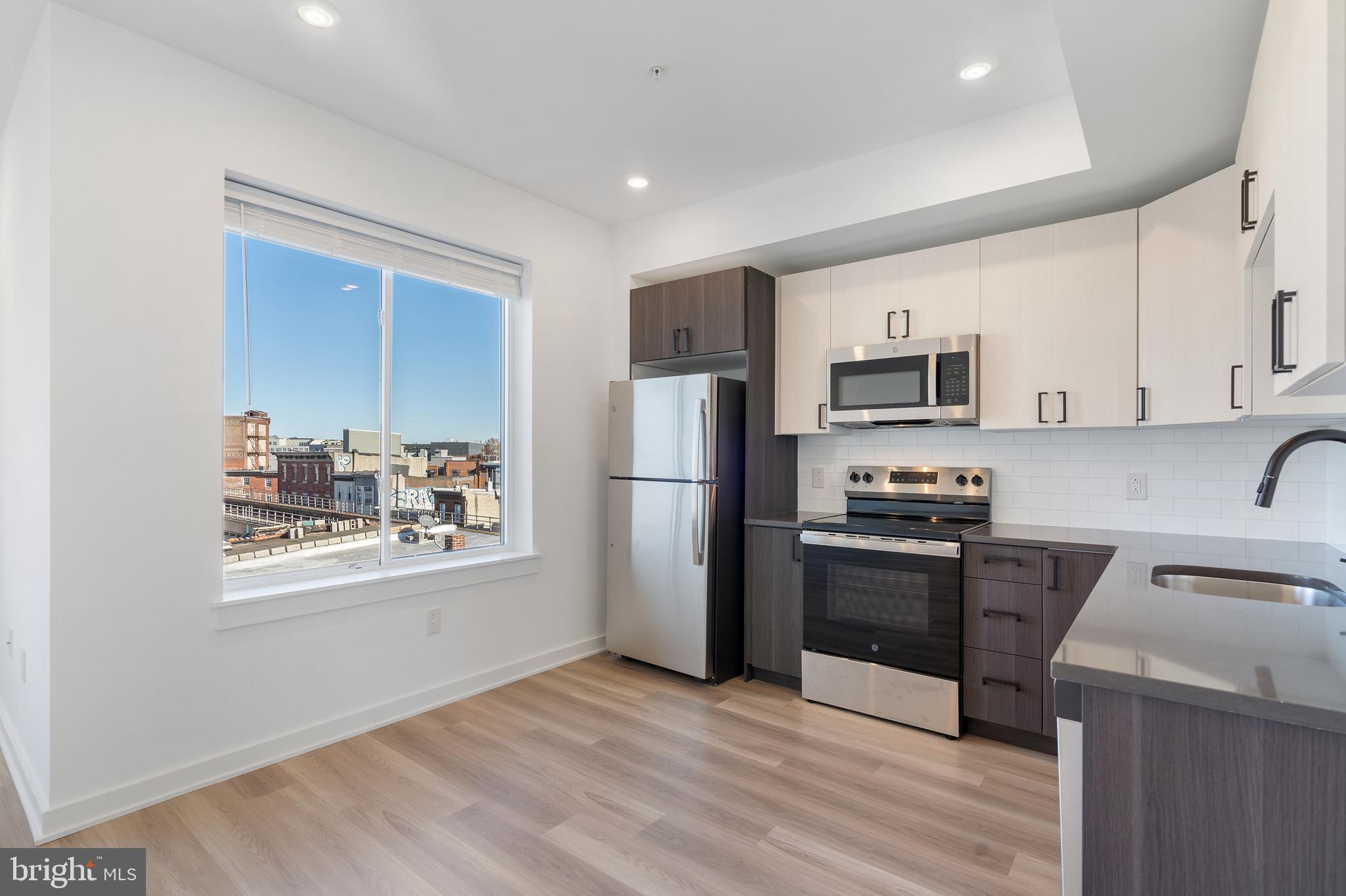 2111 North Front Street, Unit 204 Philadelphia, PA 19122 - Photo 1 of 13 a kitchen with stainless steel appliances a refrigerator stove microwave and sink