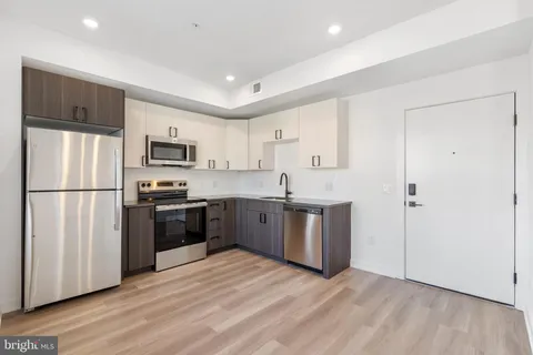 a kitchen with stainless steel appliances a refrigerator sink and microwave