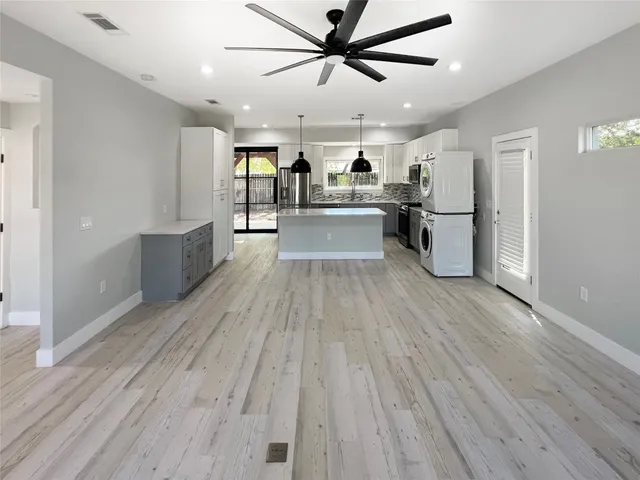 a large kitchen with cabinets wooden floor and stainless steel appliances