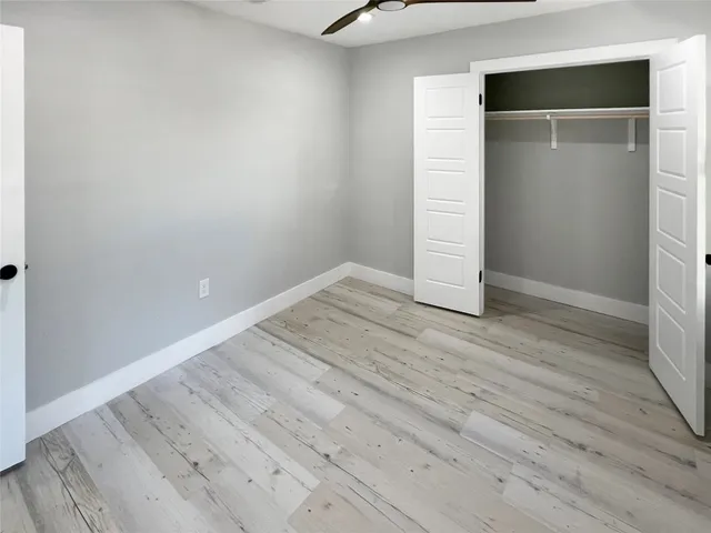 an empty room with wooden floor and closet