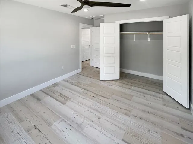 an empty room with wooden floor and closet